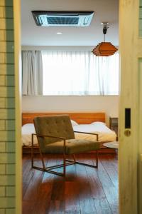 a bedroom with a bed and a chair and a window at THE ROOT2 HOTEL in Kyoto
