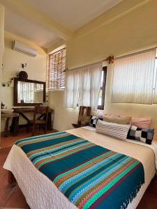 a bedroom with a large bed with a colorful blanket on it at Hotel Artesanal Palomera in San Francisco