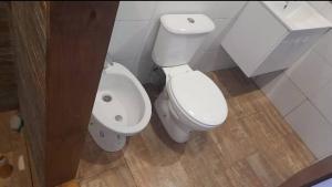 a bathroom with a white toilet and a bidet at Vertiente escondida in Villa Yacanto