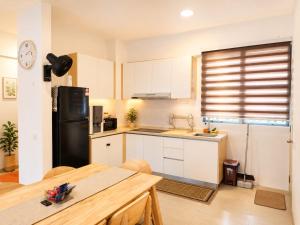 a kitchen with white cabinets and a black refrigerator at Seaview mutiara melaka Pantai puteri in Gua Sai