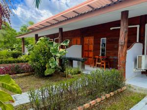 a wooden house with a garden in front of it at Poonsap Resort in Ko Lanta