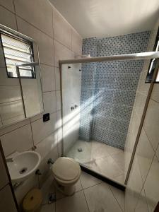 a bathroom with a shower and a toilet and a sink at Grande Hotel in Duque de Caxias