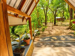a view from the porch of a house with plants at wood cabin sigiriya in Sigiriya +14 photos