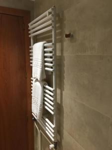 a towel rack in a bathroom with white towels at Hostal La Placeta in Camprodon