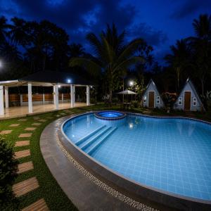 a swimming pool in a resort at night at The Siblings Farm House in Liliw
