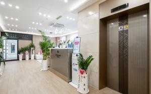 a lobby with potted plants in a building at Brown Dot Hotel Daecheon Beach, Boryeong in Boryeong
