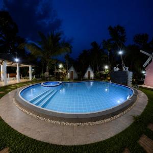 a swimming pool at night with lights on at The Siblings Farm House in Liliw
