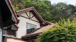 a house with a balcony and trees in the background at geoje yeoul pet-friendly pension in Yŏch'a
