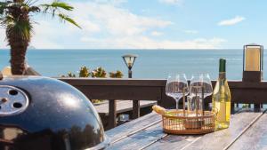 a table with wine bottles and glasses on the beach at geoje yeoul pet-friendly pension in Yŏch'a