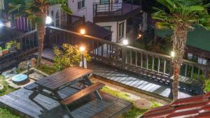 a wooden bench sitting on a deck at night at geoje yeoul pet-friendly pension in Yŏch'a +1 photo