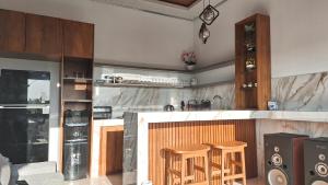 a kitchen with a counter and two stools at Villa Kasuri Bali in Blahbatu