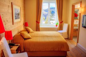 a bedroom with a bed and a window at Maloja Palace Residence Engadin-St Moritz CO2-Neutral in Maloja