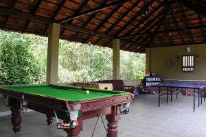 a pool table in a room with two tables at The Road's End in Gonikoppal