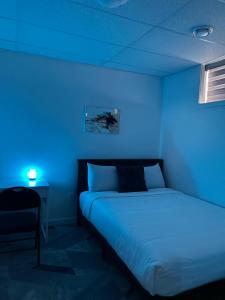 a blue room with a bed and a table with a lamp at AYBAM's House in Winnipeg