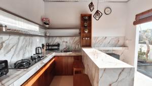 a kitchen with marble counter tops and a sink at Villa Kasuri Bali in Blahbatu