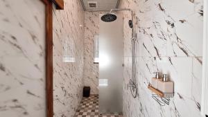 a bathroom with a shower and a tiled floor at Villa Kasuri Bali in Blahbatu +26 photos