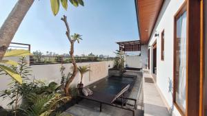 a plunge pool on the balcony of a house at Villa Kasuri Bali in Blahbatu