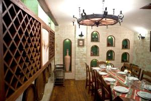 a dining room with a long table with chairs and a chandelier at Shirak Hotel in Yerevan