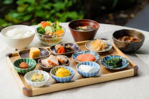 a tray of food with bowls of food on a table at Hotel Resol Trinity Kyoto in Kyoto