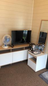 a entertainment center with a flat screen tv and a fan at Beji Bedugul Glamping in Bedugul +34 photos