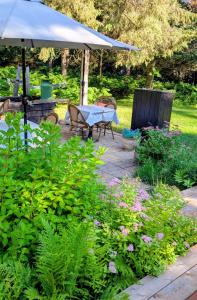 a garden with a table and chairs and an umbrella at La Tremblante in Mont-Tremblant +34 photos