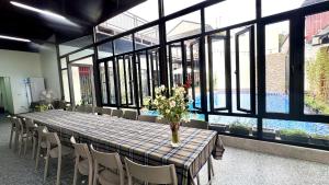 a long table with chairs and a vase of flowers on it at PALM Minh Chau Hotel-Only for Vietnamese in Quang Ninh