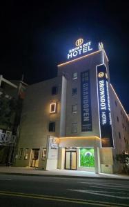a hotel with a neon sign on top of it at Brown Dot Hotel Daecheon Beach, Boryeong in Boryeong