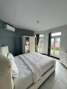 a bedroom with a white bed and a blue wall at new pratama in Sampal 2 +29 photos