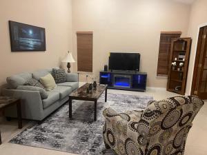 a living room with a couch and a tv at Hutchinson River House in Fort Pierce