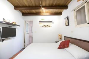 a bedroom with a bed and a flat screen tv at 任我行民宿 in Jincheng