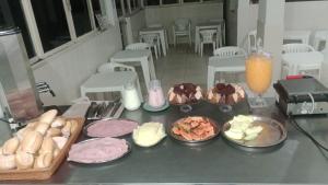 a table topped with plates of food on a counter at Hotel Gênio in Pouso Alegre