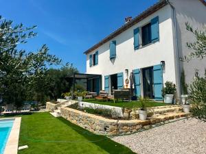 a house with a garden and a swimming pool at Prestige villa Estrella in Fayence