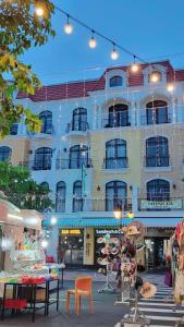 a large building with tables and chairs in front of it at Xan hotel in Phú Quốc