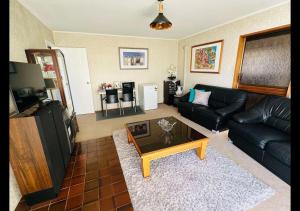 a living room with a couch and a coffee table at Private 2-Bedroom Suite in 3-Bedroom House in Auckland