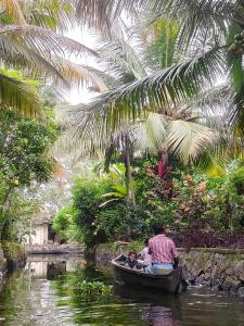 a man and two children in a boat on a river at Lakecampers for foreign travellers in Alleppey