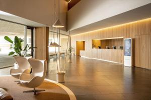 a lobby with two white chairs and a table at Meliá Palma Bay in Palma de Mallorca