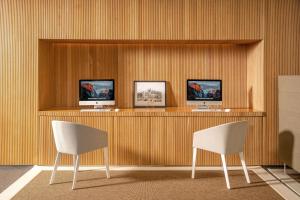 two chairs and a counter with two monitors on it at Meliá Palma Bay in Palma de Mallorca