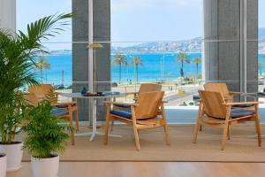 a room with chairs and a table and a view of the beach at Meliá Palma Bay in Palma de Mallorca +54 photos