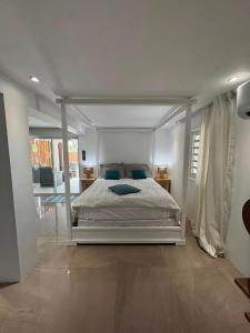a bedroom with a white bed with a canopy at FIG PARADIS the villa in Philipsburg