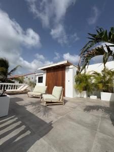 a patio with two lounge chairs and a building at FIG PARADIS the villa in Philipsburg