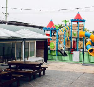 a park with a playground with a water slide at Manning River Motel in Taree