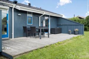 a deck with a table and chairs on a house at G112-Lemvig-Anemonevej-12 in Lemvig +17 photos