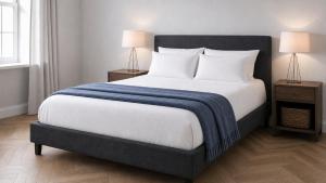 a bedroom with a large bed with a blue blanket on it at Wood Street Haven in Greytown