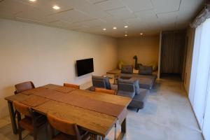 a room with a table and chairs and a couch at ERUMAYA Resort in Motobu