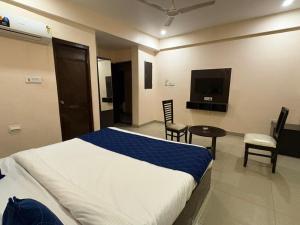 a bedroom with a bed and a table and a tv at HOTEL SILVER STONE INN in Lucknow