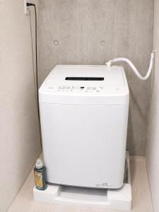 a white washing machine sitting in a bathroom at NEW OPEN!! SLEEPLAB 池袋 -ikebukuro- in Tokyo
