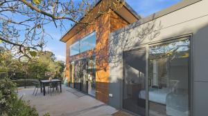 a glass extension of a house with a patio at WARM Sunlit Sustainable north facing Studio in Hawker