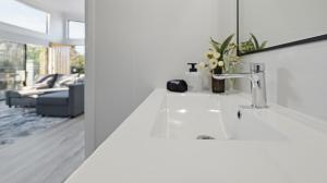 a white bathroom with a sink and a mirror at WARM Sunlit Sustainable north facing Studio in Hawker +32 photos