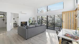 a living room with a couch and a large window at WARM Sunlit Sustainable north facing Studio in Hawker
