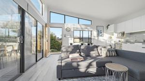 a living room with a couch and a kitchen at WARM Sunlit Sustainable north facing Studio in Hawker